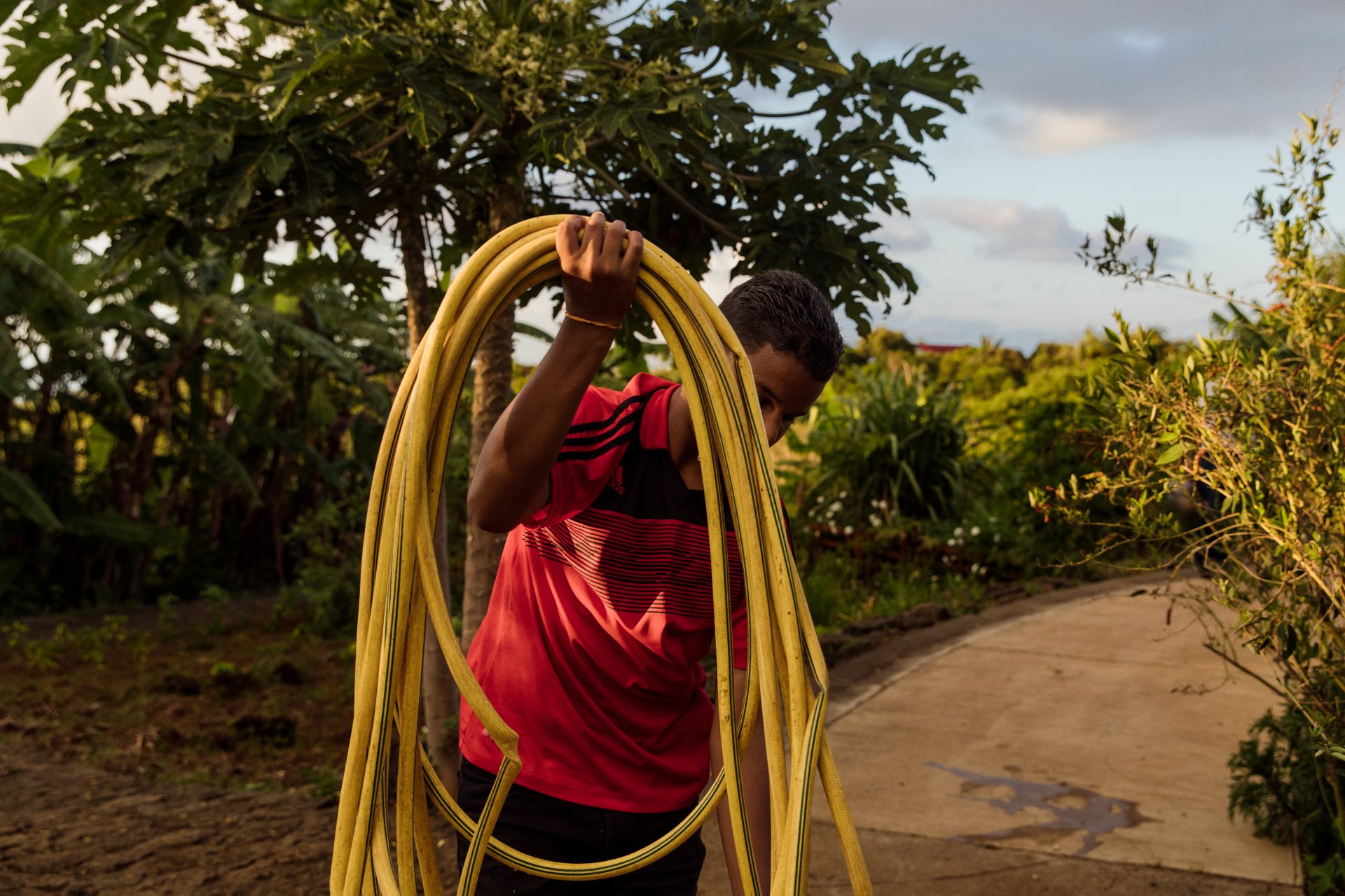 13-year-old boy watering his plot at a collective garden