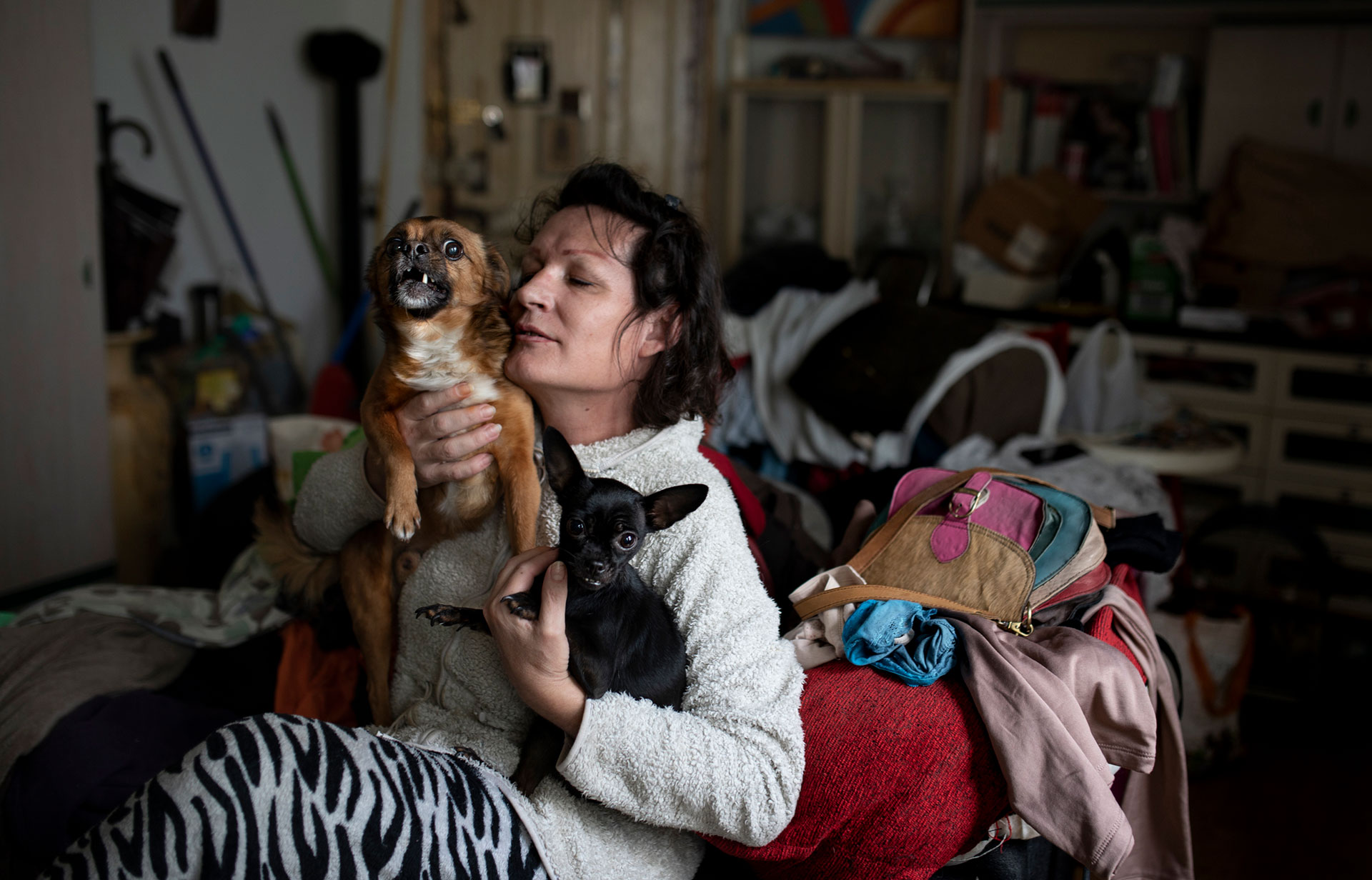 A woman holds her two dogs.