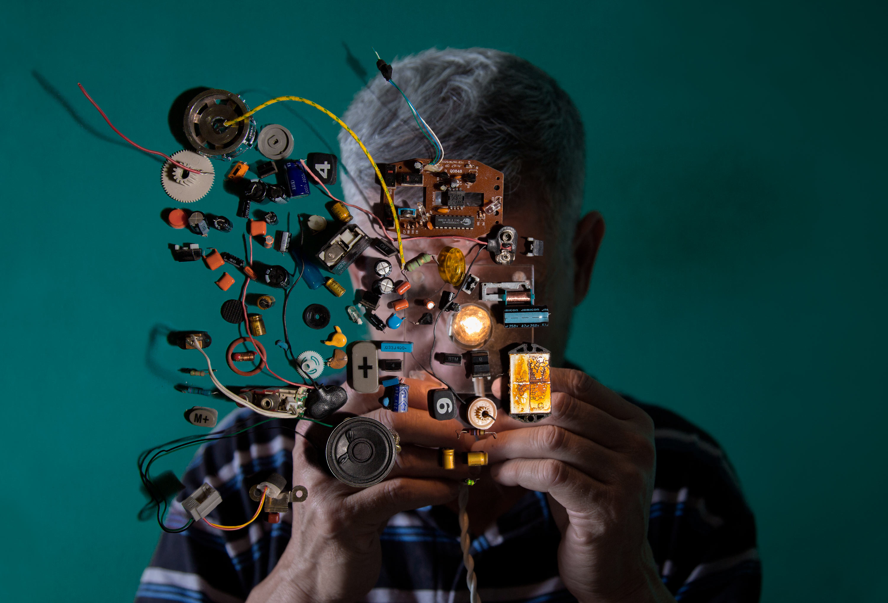 A portrait of the photographer’s uncle looking at electrical equipment.