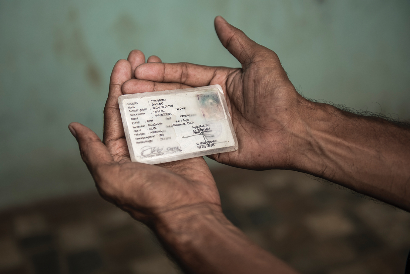 A trans woman holds ID card, which has her old name on it.