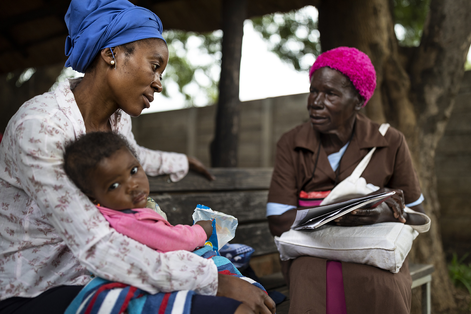 A grandmother volunteer at the Mbare Poly Clinic counsels a young mother.