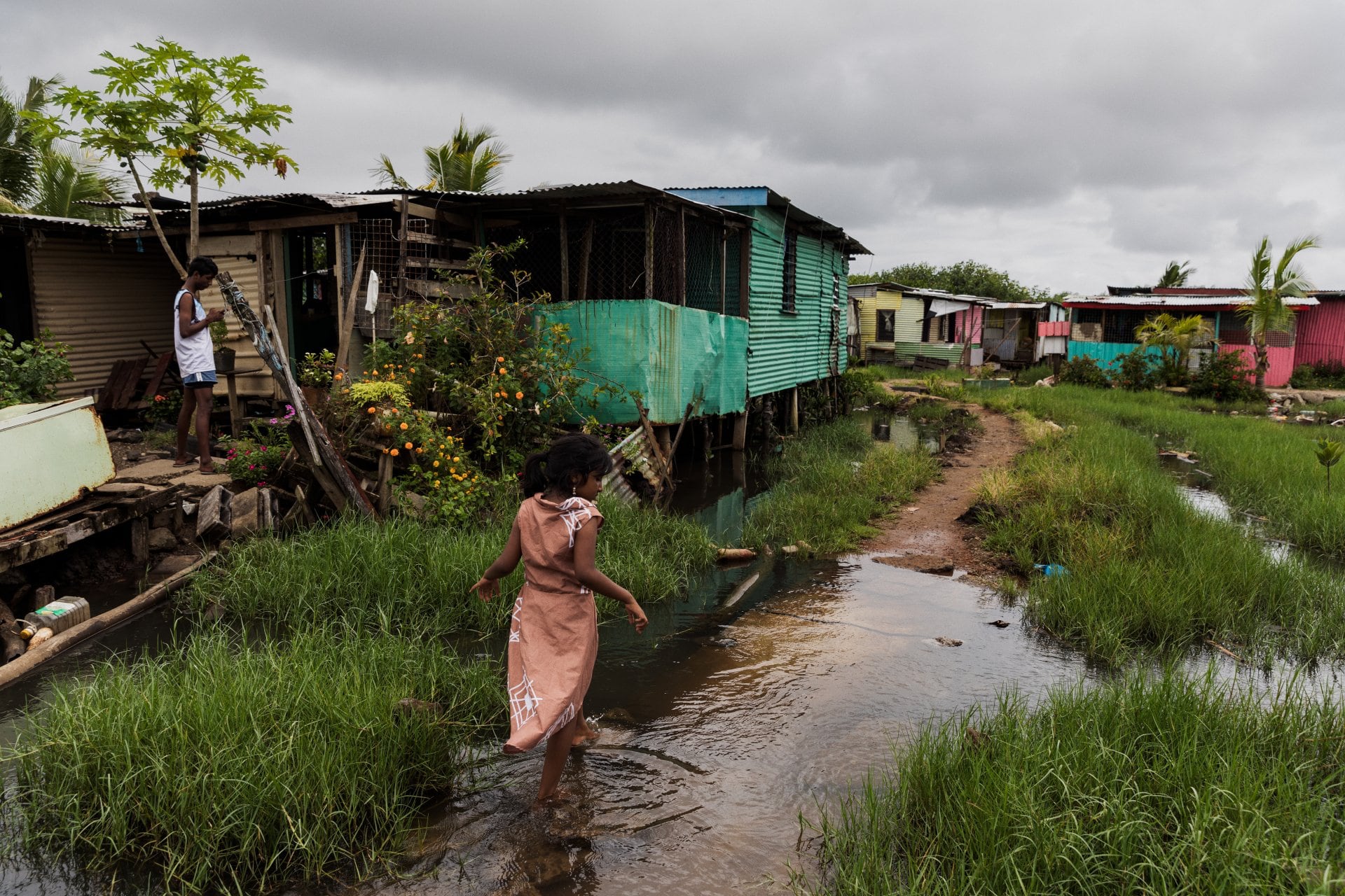 Woman walking behind her house in Nanuku settlement