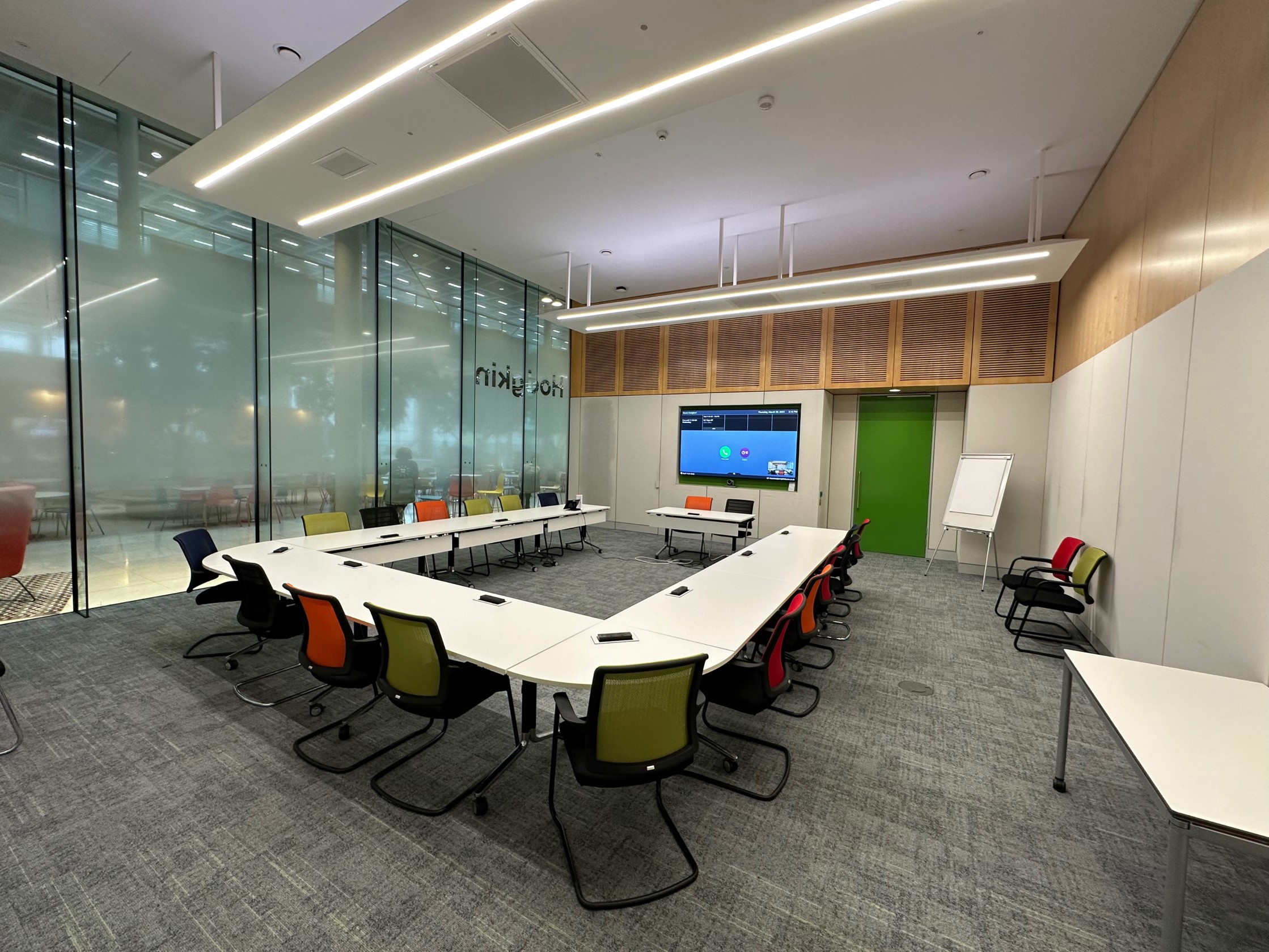 An example interview room, with a screen against the far wall and chairs and tables arranged in a U-shape.