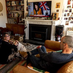 A group of neighbours watch Prime Minister Jacinda Ardern announcing the lifting of all social distancing restrictions in New Zealand