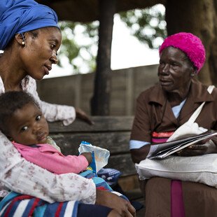 A grandmother volunteer at the Mbare Poly Clinic counsels a young mother.