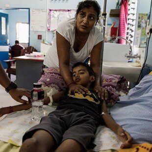 Young boy with dengue lying in a hospital bed