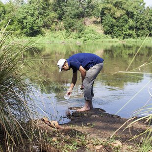 Upul takes a water sample from the Mahaweli river