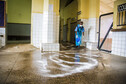 Cleaner using chlorine powder to disinfect emergency entrance to Connaught Hospital, Sierra Leone