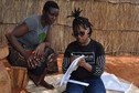 A young girl carries out research with a participant in Zambia.