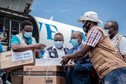 Airport staff and health personnel handle boxes with doses of AstraZeneca Covid-19 vaccines.