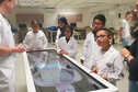 Children and scientists look at an image showing organs of the human body