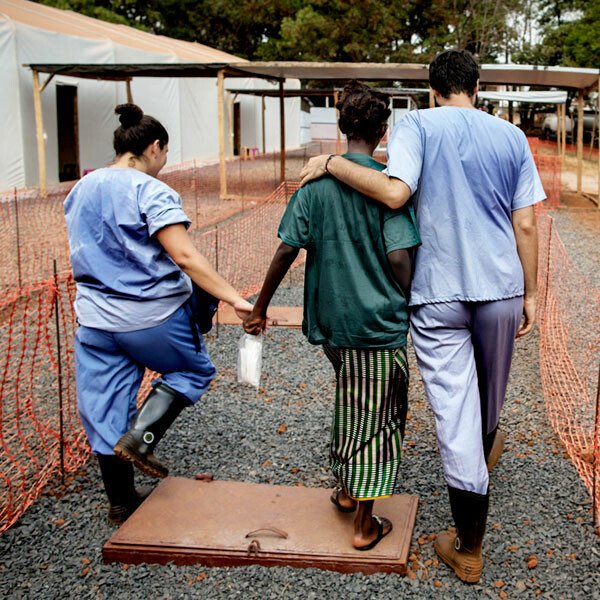 A patient with health workers at an Ebola treatment facility built by Médecins Sans Frontières in Freetown, Sierra Leone. 