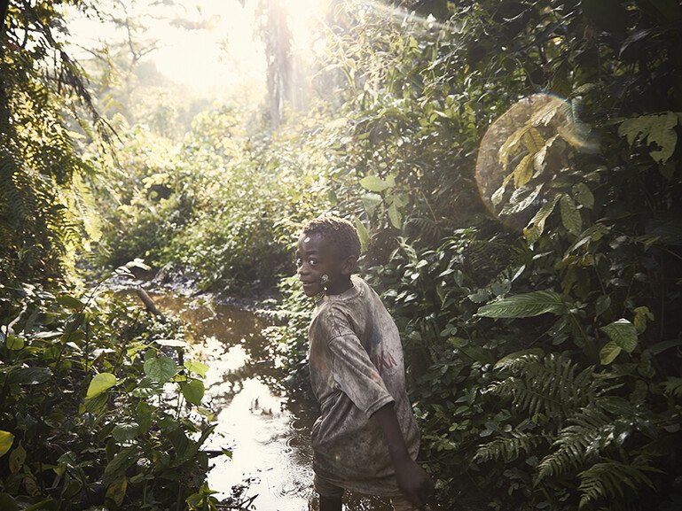 An Mbuti boy runs through the Ituri rainforest.