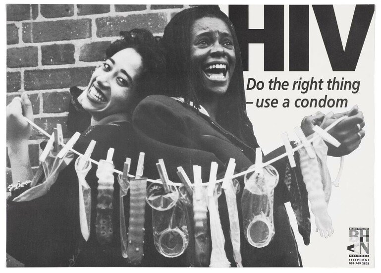 Two women hold a washing line to which condoms are pegged; advertising safe sex and AIDS prevention.