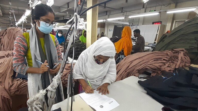 Researchers conduct a survey with workers in a ready-made garment factory.