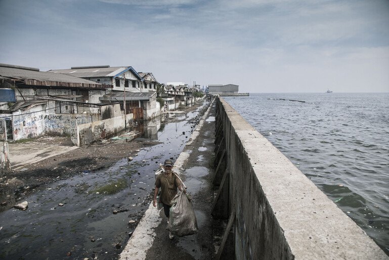 A man walks along the giant sea wall protecting Jakarta in Indonesia 