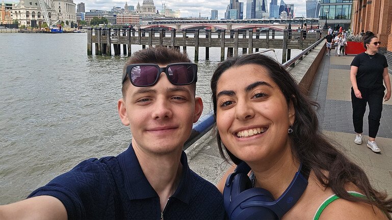 Remi Pereszczak and Nadine take a selfie beside the River Thames in London.