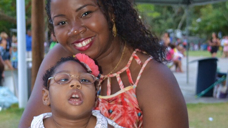 A mother holding her toddler daughter, who has congenital Zika syndrome