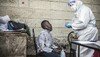 A young boy selling face masks in the streets of the Kawangware slums, in Kenya, is being tested for coronavirus.