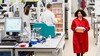 A researcher wearing a red lab coat in the Sequencing Centre at the Wellcome Sanger Institute