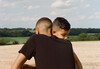 Two brothers hug in a park a few days after lockdown restrictions were eased.