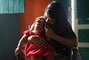 A mother cradles her daughter, who was born with congenital Zika syndrome. 