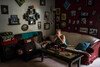 A mother sits on her sofa wiping away tears after dealing with one of her son's emotional outbursts.  