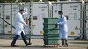 Two scientists are wheeling a stack of boxes with Covid-19 tests.