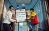 A group of men unload a box that says 'COVAX' from a truck.