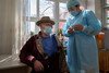 A healthcare professional gives a older man his Covid-19 vaccination in Mongolia