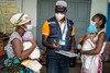 In the Ampasimandrorona district, Madagascar, a doctor speaks to the grandmother and mother of twins about the importance of vaccinating the infants.