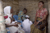 In a village in South Africa, a woman speaks to two mothers who are nursing their young babies.