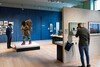 View of the 'Being human' exhibition at Wellcome Collection. Two men interact with the exhibits.